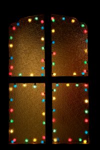 Christmas window decorated with multicolor lights on a black backgound. Space for copy, high resolution - 16 Mpx. You can add black space for text to any side.